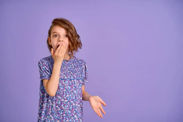 Young girl wearing flower print dress over purple isolated background shocked covering mouth with hand. — Stock Photo, Image