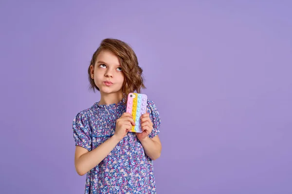 Little girl holding telephone isolated over violet color background — Stock Photo, Image