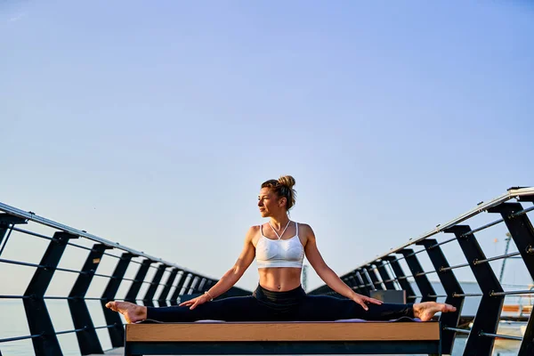 Mooie jonge vrouw doet yoga oefening op de natuur in de ochtend. — Stockfoto