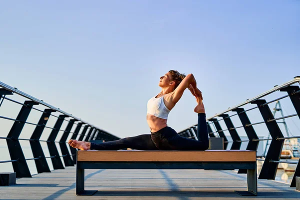 Mooie jonge vrouw doet yoga oefening op de natuur in de ochtend. — Stockfoto