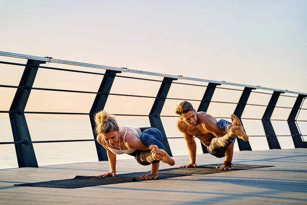 Pár cvičí jógu spolu venku na přírodě. Ranní cvičení při východu slunce. — Stock fotografie