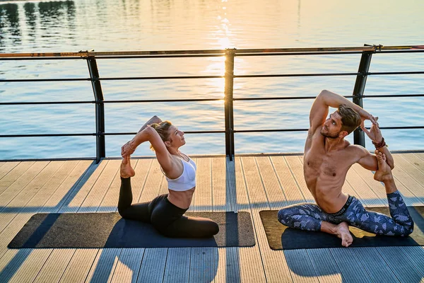 Pareja haciendo yoga juntos en la naturaleza al aire libre. Ejercicios matutinos al amanecer. —  Fotos de Stock