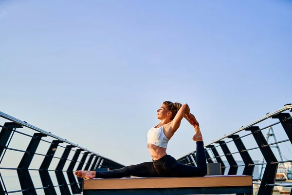 Mujer bastante joven haciendo ejercicio de yoga sobre la naturaleza en la mañana. —  Fotos de Stock