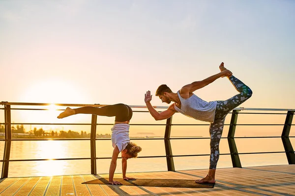 Pareja haciendo yoga juntos en la naturaleza al aire libre. Ejercicios matutinos al amanecer. —  Fotos de Stock