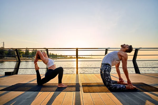 Pareja haciendo yoga juntos en la naturaleza al aire libre. Ejercicios matutinos al amanecer. —  Fotos de Stock