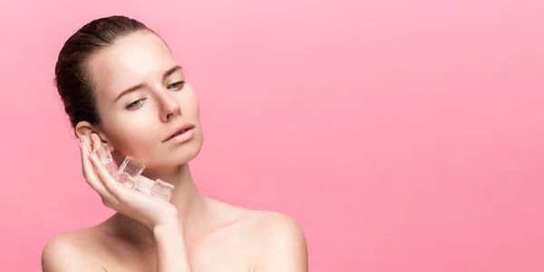 Mooie vrouw met natuurlijk uitziende make-up houden ijsblokjes in de buurt gezicht — Stockfoto