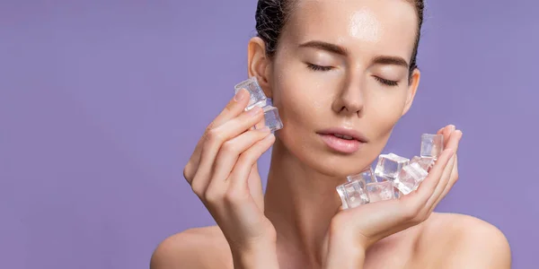 Beautiful woman with natural looking makeup holding ice cubes near face — Stock Photo, Image