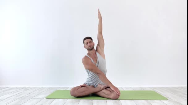 Erkek yoga, beyaz arka planda klasik pozlarda meditasyon yapar. — Stok video