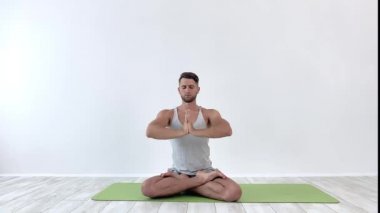 Erkek yoga, beyaz arka planda klasik pozlarda meditasyon yapar.