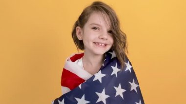 Vatansever bayram. Mutlu çocuk, sarı stüdyo geçmişinde Amerikan bayrağı olan sevimli kız. ABD 4 Temmuz Bağımsızlık Günü 'nü kutladı