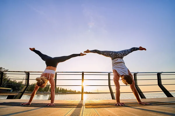 Pareja haciendo yoga juntos en la naturaleza al aire libre. Ejercicios matutinos al amanecer. —  Fotos de Stock