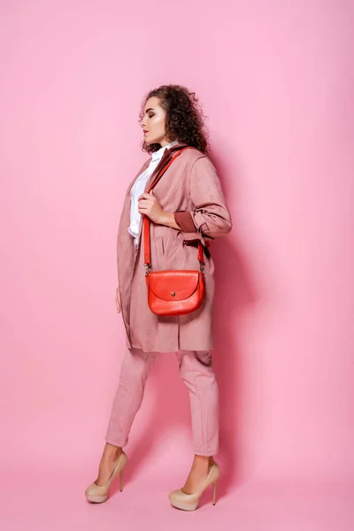 유행하는 핑크 코트를 입은 젊고우아 한 여성. 고립된 스튜디오 샷 — 스톡 사진