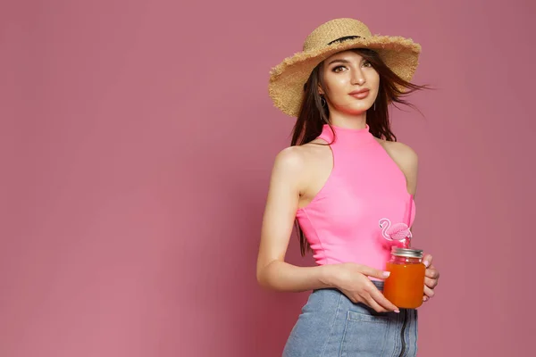 Studio portret van vrij schattig schattig prachtig dame met glas sap in de hand het dragen van stro hoed geïsoleerd op roze achtergrond — Stockfoto