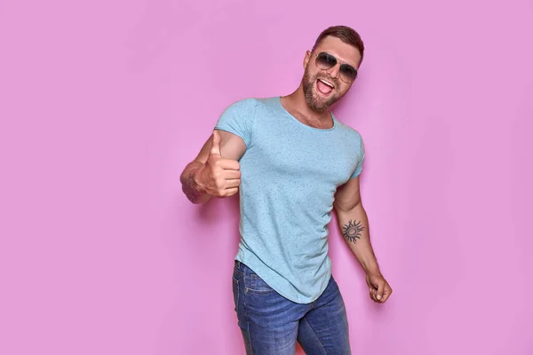 Hombre barbudo con sombrero y gafas de sol mostrando los pulgares hacia arriba — Foto de Stock