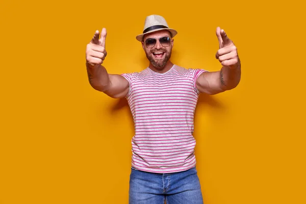 Junger gutaussehender Mann in lässigem T-Shirt vor isoliertem gelben Hintergrund, der mit dem Finger in die Kamera und zu Ihnen zeigt, Handzeichen, positive und selbstbewusste Geste — Stockfoto