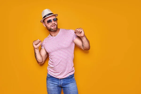 Porträt des optimistischen funky guy dance tragen Sommer-Look Strohhut, Sonnenbrille isoliert auf gelbem Hintergrund — Stockfoto