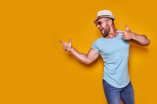 Hombre joven de vacaciones con camisa y sombrero de verano sobre fondo amarillo señalando el dedo con una idea exitosa. — Foto de Stock