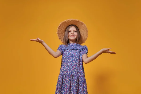 Funny child girl smiling with spread hands on yellow background — Stock Photo, Image