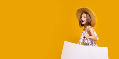 Hasır Şapkalı Neşeli Genç Kızın portresi Sarı Arkaplan Üzerinde Parlak Alışveriş Çantaları, Boşluğu Kopyala