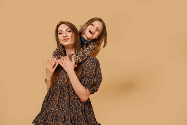 Дві красиві сестри молодих дівчат в гарних сукнях з візерунком тварин з солом'яними капелюхами позує в студії — стокове фото