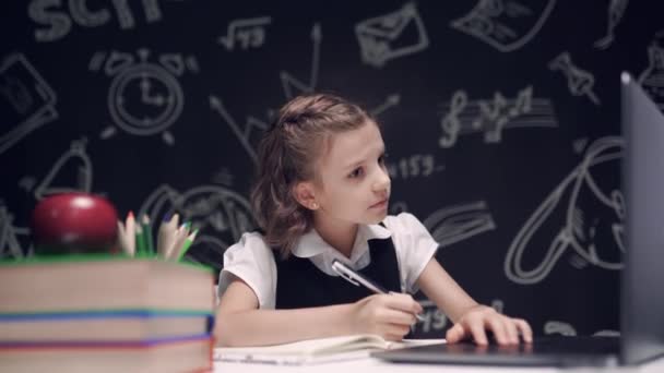 Estudiante adolescente de la escuela que estudia con los libros del ordenador portátil que hacen asignación en línea de la tarea de la investigación, muchacha adolescente blanca caucásica usando la computadora y escribiendo algo en el cuaderno — Vídeos de Stock