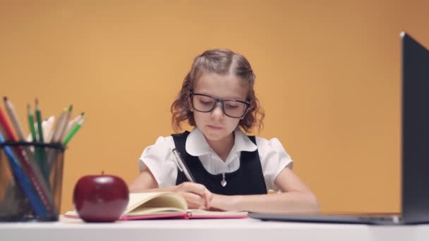 Fröhliches kleines Mädchen im Kopfhörer mit Laptop durch Online-E-Learning-System lernen. — Stockvideo