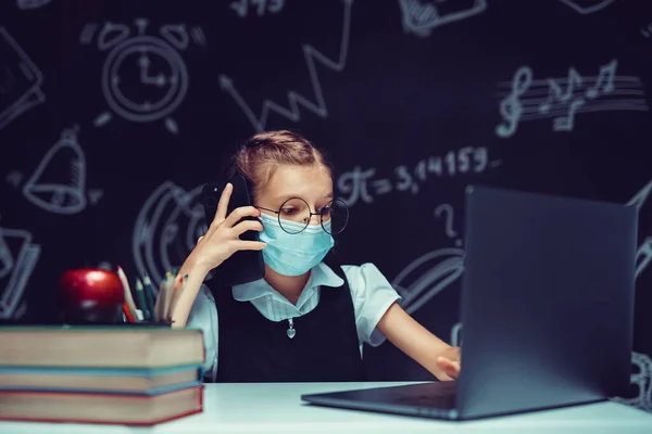 Junior student bär medicinsk mask online virtuell inlärning språk klass talar mobiltelefon — Stockfoto