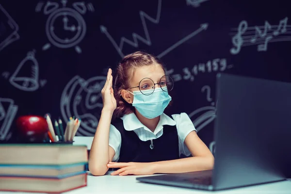 Junior student bär medicinsk mask på nätet virtuell inlärning språk klass på bärbar dator. — Stockfoto