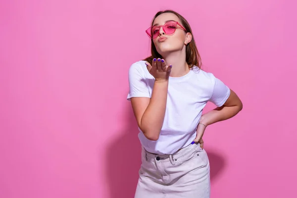 Wanita muda dengan latar belakang merah muda yang terisolasi dengan kacamata — Stok Foto