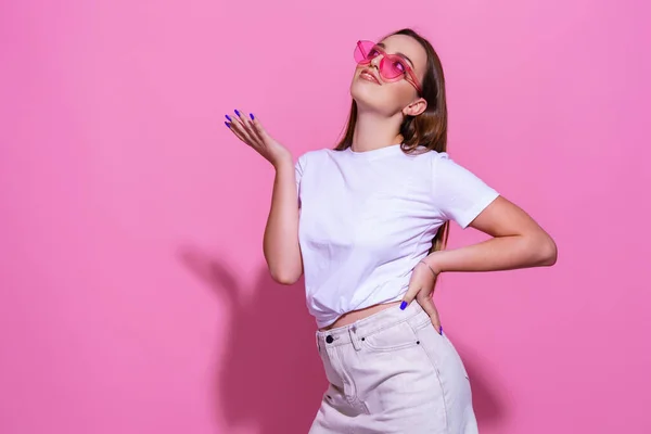 Mujer joven sobre fondo rosa aislado con gafas — Foto de Stock