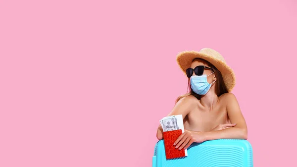 Wanita muda menunggu penerbangan, duduk di lantai dekat kopernya, mengenakan masker wajah untuk mencegah serangan jantung — Stok Foto
