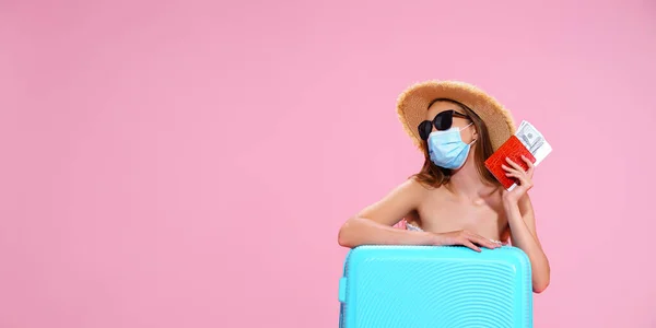 Wanita muda menunggu penerbangan, duduk di lantai dekat kopernya, mengenakan masker wajah untuk mencegah serangan jantung — Stok Foto