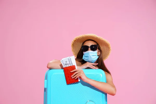 Jonge vrouw wachtend op vlucht, zittend op de vloer in de buurt van haar koffer, met gezichtsmasker om coronavirus te voorkomen — Stockfoto