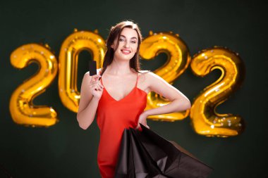 Kredi kartı ve alışverişi olan bir kadın. Yeni yıl alışverişi. Kara Cuma. 2022 balon satışı