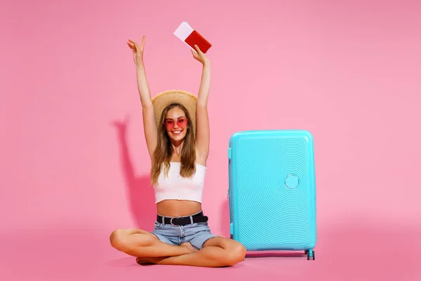 Vrouw toerist, reiziger met paspoort en tickets, koffer, wit topje, shorts, strohoed. — Stockfoto