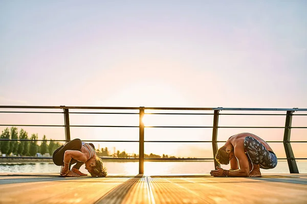 Pareja practicando yoga acrobático juntos en la naturaleza al aire libre en el mar. —  Fotos de Stock