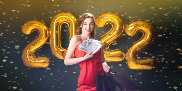 Žena drží dolary a nákupy. Nový rok nakupování. Černý pátek. 2022 balónů. prodej. Oslavit — Stock fotografie