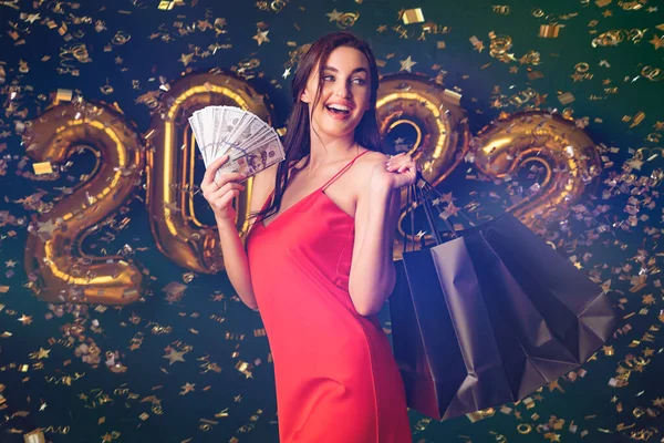 Frau mit Dollars und Einkäufen. Neujahrseinkauf. Schwarzer Freitag. 2022 Ballons. Weihnachtsgeschäft — Stockfoto