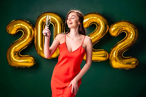 Neujahrsparty. 2022 Luftballons Konfetti grünen Hintergrund. Frau mit Champagner. Feiern — Stockfoto