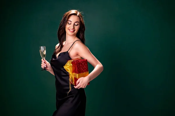 ブラックドレスの女性は、シャンパンのギフトボックスとガラスを保持しています。パーティーの時間だ。休日のコンセプト — ストック写真