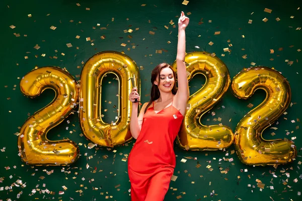 Mulher excitada em vestido vermelho segurar copo de champanhe. Ano Novo 2022 celebração festa de férias conceito — Fotografia de Stock