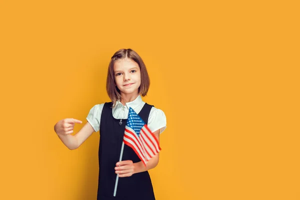 Söt kaukasisk skolflicka med amerikansk flagga pekande med hand och finger. Förenta staternas flagga — Stockfoto