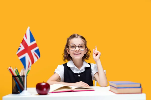 笑容满面的高加索女学生举起食指.英语课。英国国旗 — 图库照片