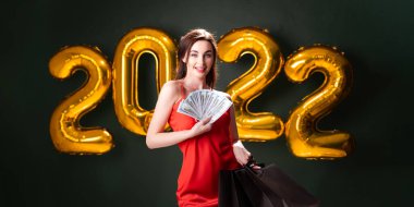 Dolarları ve alımları olan bir kadın. Yeni yıl alışverişi. Kara Cuma. 2022 balon. Noel satışları