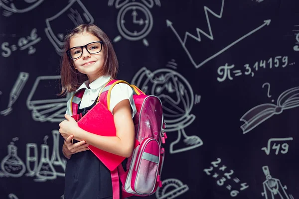 Aluno bonito em óculos preparando-se para ir à escola com mochila e reservar em mãos. De volta à escola — Fotografia de Stock