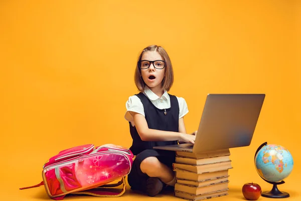 Comprimento total surpreendido estudante sentado atrás de uma pilha de livros com laptop conceito de educação para crianças — Fotografia de Stock