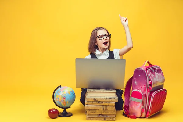 Emotionaler Schüler sitzt hinter Bücherstapel, Laptop hebt Hand mit Zeigefinger. Bildung für Kinder — Stockfoto