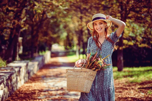 Lächelndes rothaariges Mädchen läuft allein im Herbstpark an sonnig warmen Tagen und hält Handtasche Indian Summer — Stockfoto