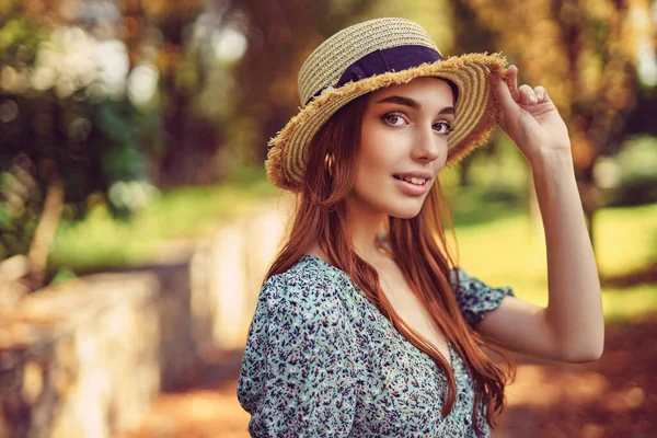 Sourire fille rousse caucasienne en robe flottante chapeau de paille posant dans le parc d'automne. Été indien — Photo