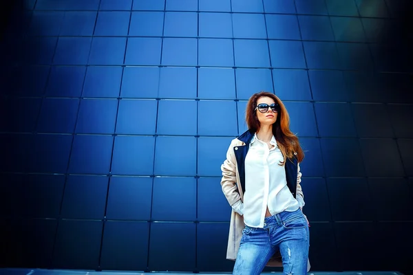 Menina em um casaco bege e jeans azuis — Fotografia de Stock